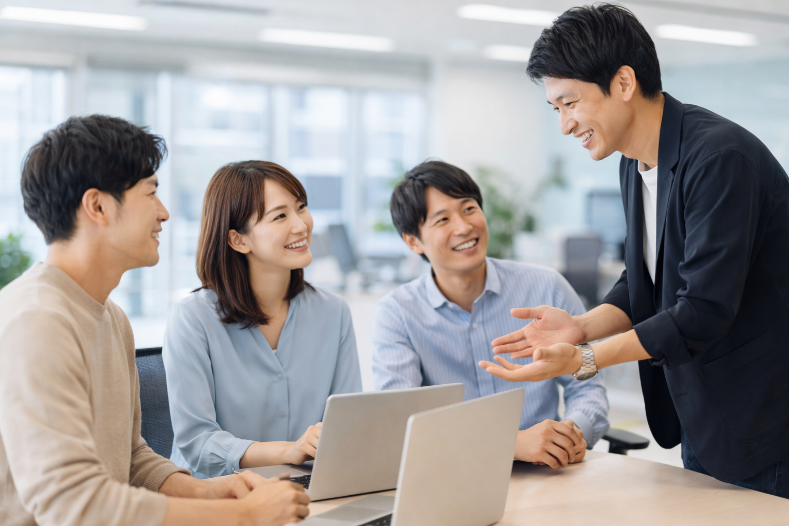 明るいオフィスで会話するエンジニアチーム